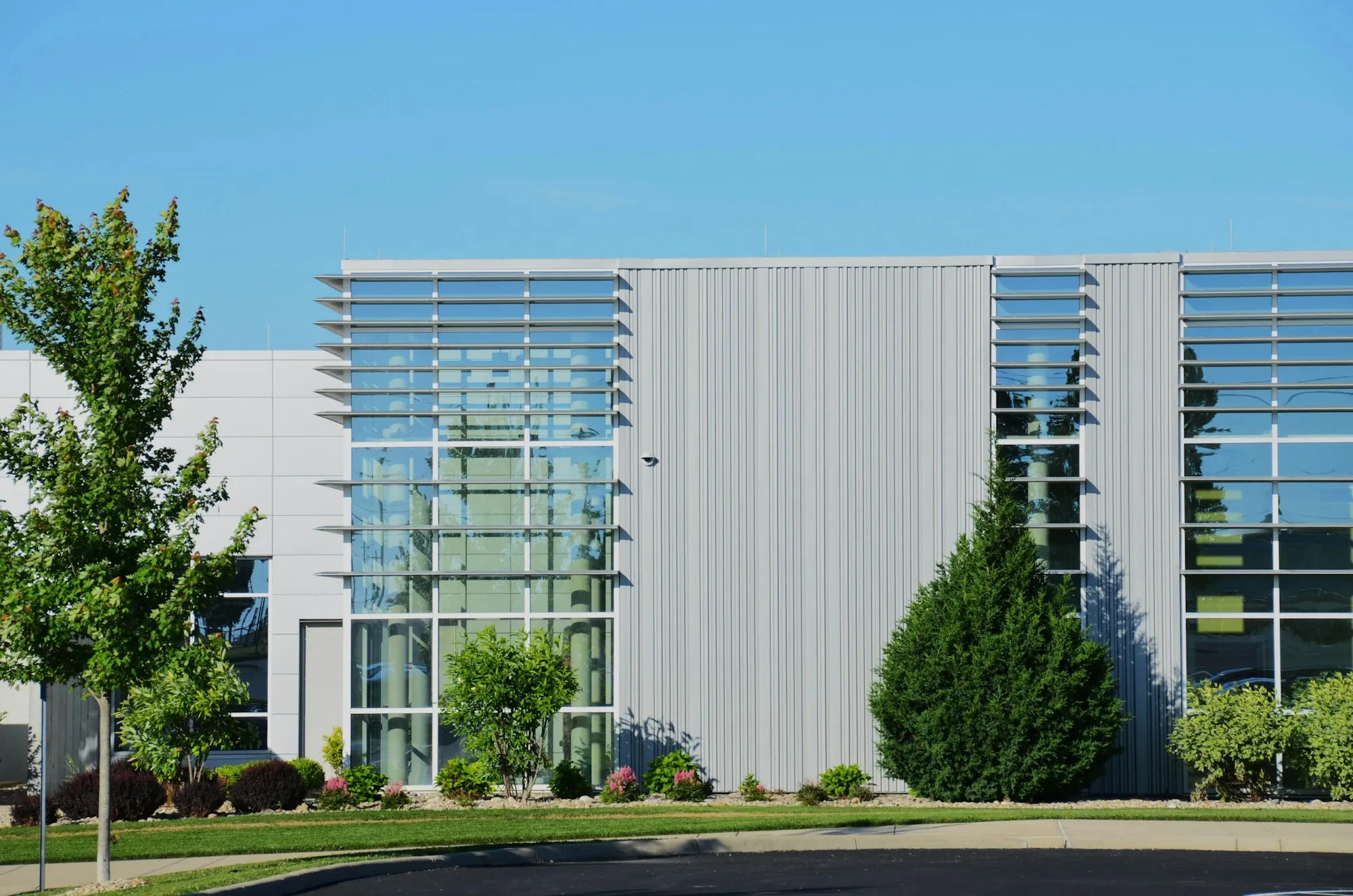 Commercial building facade with trees and a lawn
