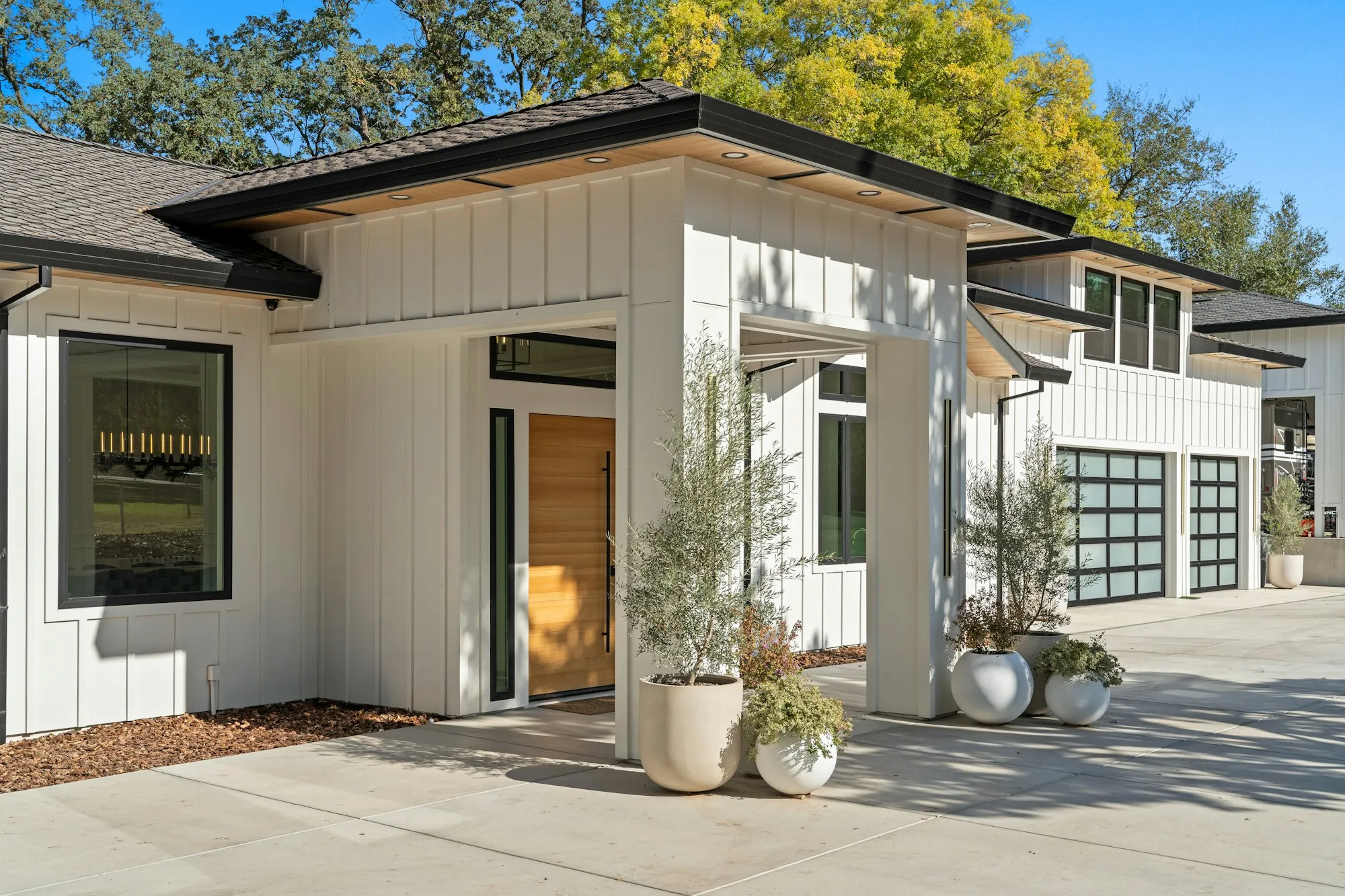 Modern white home with a concrete entry walk and planters